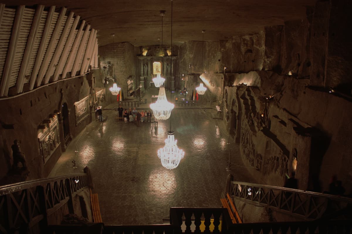 A Capela de Santa Kinga no interior das Minas de Sal de Wieliczka, perto de Cracóvia — uma vasta igreja subterrânea esculpida inteiramente em sal-gema, iluminada por candelabros de cristal de sal.
